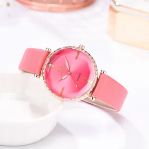 Détail du boîtier en or rose avec strass et bracelet en cuir rose sur montre à quartz
