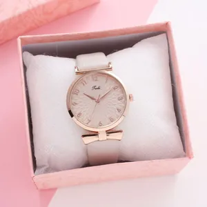 Detail of quartz watch with rose gold bow and cream leather strap in gift box
