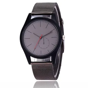Detail of minimalist quartz watch featuring grey dial and gunmetal mesh strap on white
