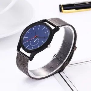 Detailed macro shot of business watch with blue dial and grey mesh strap near office desk