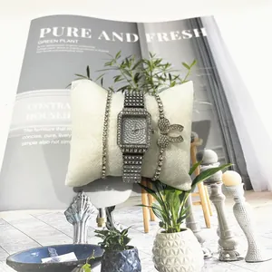 Detail eines luxuriösen quadratischen Quarzuhren-Sets mit Strasssteinen und Armbändern