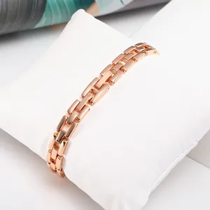 Close-up of rose gold H-link chain bracelet on white pillow with high-polish finish