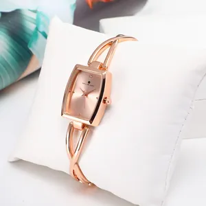 Women's rose gold rectangular quartz watch with cutout crossover bracelet strap on pillow