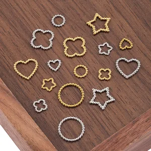 Detail view of gold and silver beaded texture metal charms in star, heart, and clover shapes