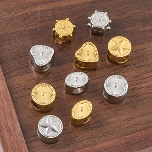 Detailed macro view of vintage heart and star metal spacer beads in gold and silver finish