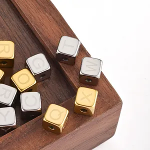 Macro shot of 6mm square stainless steel letter beads in gold and silver finish