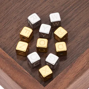 Macro shot of 6mm square stainless steel letter beads in gold and silver on wood