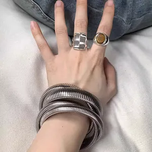 Detail of silver stretch snake chain bracelet and rings on wrist with amber gemstone