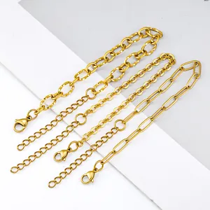 Trois bracelets dorés en acier inoxydable avec mailles trombone et ovales et fermoir mousqueton
