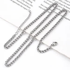 Gros plan d'un collier chaîne épi argentée avec fermoir mousqueton et extension