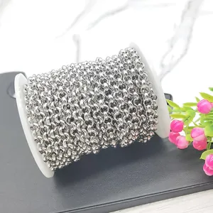 Polished silver stainless steel round link chain on white spool for DIY jewelry making