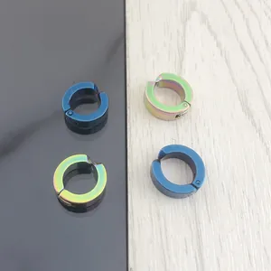 Dettaglio di quattro clip per orecchie in acciaio lucido nei colori blu scuro e iridescente