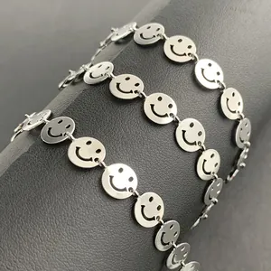 Polished stainless steel smiley face link chain bracelet on a dark display stand