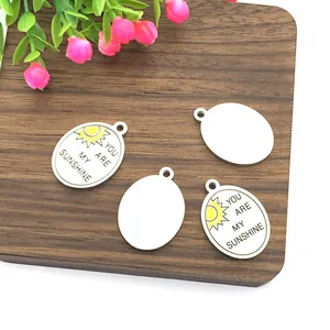 Oval stainless steel sun pendants with You Are My Sunshine engraving on wood background