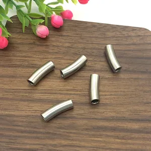 Five matte stainless steel curved tube beads for DIY necklace on dark wood background