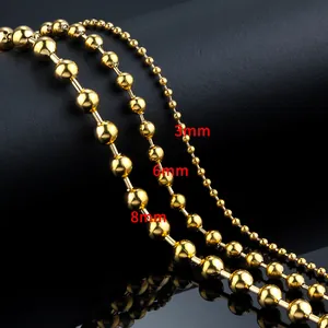 Detail showing 3mm, 6mm and 8mm golden stainless steel ball chains on black surface