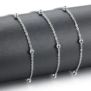 Polished silver stainless steel bead chain necklace wrapped on a dark textured display