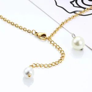 Detailed macro of a gold ball-pin chain featuring a lobster clasp and white pearls