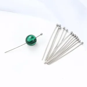 Detail of stainless steel ball head pins showing a green striped bead on a silver pin