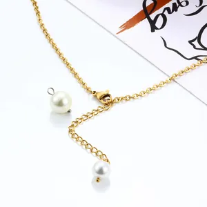 Detail of gold necklace chain with white pearl pendant and lobster clasp on white background