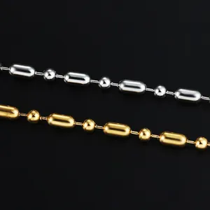 Polished gold and silver stainless steel beaded chains with capsule beads in macro view