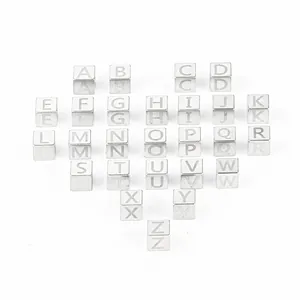 Polished 7mm stainless steel alphabet beads arranged in a heart shape for DIY jewelry