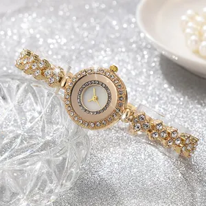Orologio al quarzo dorato da donna con strass scintillanti su lussuoso sfondo argentato
