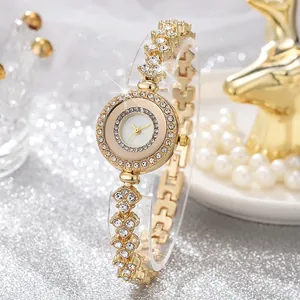 Dettaglio dell'orologio da donna dorato con lunetta e cinturino decorati con cristalli