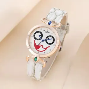 Detail view of clown face dial on rose gold quartz watch with white leather strap