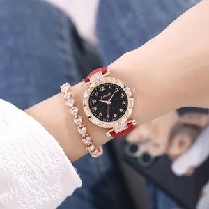 Dettaglio dell'orologio con quadrante stellato, cinturino rosso e bracciale a cuore