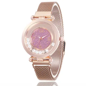 Detail view of rose gold mesh strap watch with sparkling glitter dial and moving rhinestones