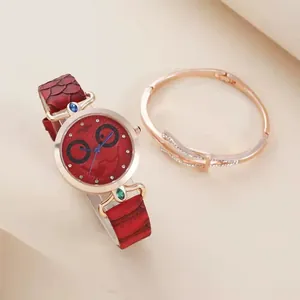 Detail of red leather watch with owl face dial and rose gold bangle set for women