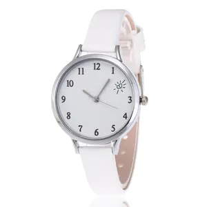 Close-up of white leather strap watch with silver case and heart motif dial