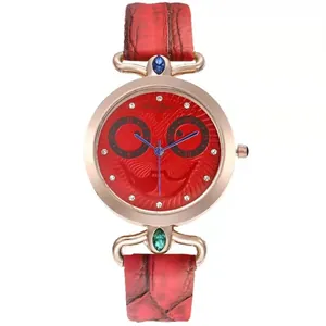 Close-up of red leather watch with rose gold owl dial and sparkling rhinestone markers