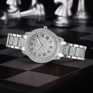 Detail view of silver full diamond luxury watch with Roman numerals on chessboard
