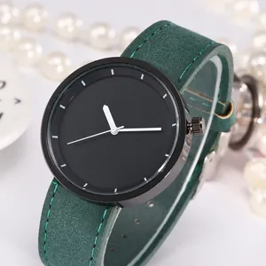 Detail of minimalist black dial watch with green suede leather strap and white stitch