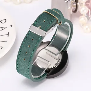 Detail of dark green matte leather strap and stainless steel buckle on a men's quartz watch
