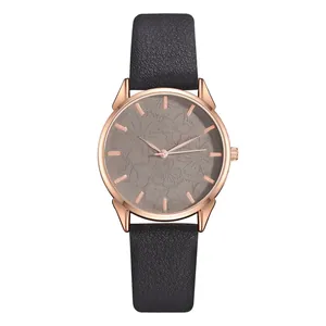 Dettaglio orologio oro rosa con quadrante grigio a rilievo floreale e cinturino in pelle nera