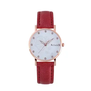 Detailaufnahme der roségoldenen Uhr mit Kristallindizes und rotem Lederarmband