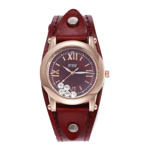 Detail of burgundy leather strap with silver rivets and moving crystals in watch case