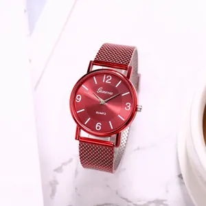 Detail of red Geneva quartz watch with mesh metal strap on white marble surface