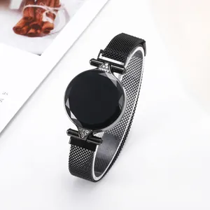 Detail of elegant black mesh strap watch with faceted glass dial and crystal accents