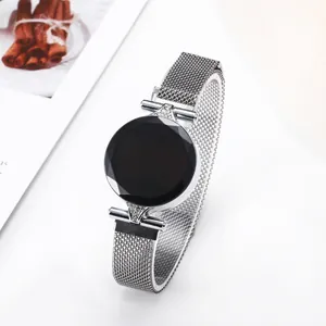 Detail of silver mesh band LED watch with rhinestone accents and black faceted dial