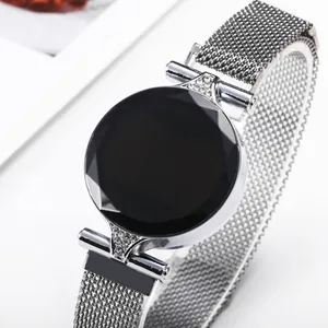 Detail view of silver mesh band watch with faceted black dial and rhinestone accents