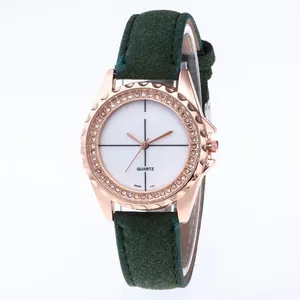 Macro shot of rose gold watch bezel with diamonds and dark green suede strap details