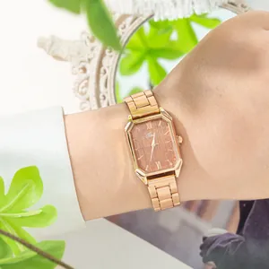 Dettaglio di un orologio quadrato in oro rosa con quadrante effetto legno al polso