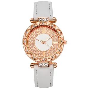 Damenquarzuhr in Roségold mit Strasssteinen und weißem Lederarmband vor weißem Hintergrund