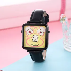 Detailopname van een vierkant cartoon quartzhorloge met zwarte lederen band op een geschenkdoos