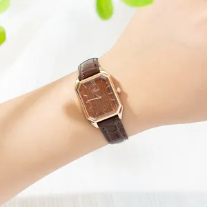 Primer plano de reloj vintage para mujer con esfera rectangular efecto madera y cuero