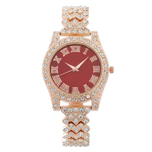 Close-up of rose gold watch with dark red roman dial and sparkling rhinestones